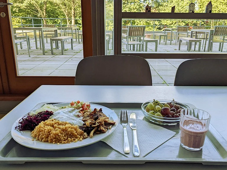 ein Tisch in der Mensa mit Tablett und Essen
